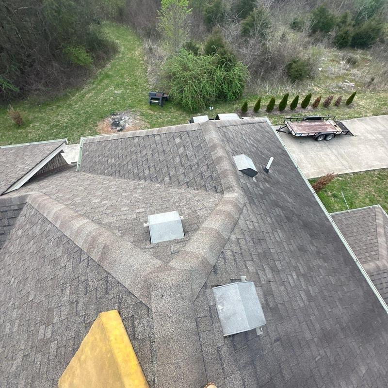 Asphalt shingle roof with ridge vent and ventilation caps