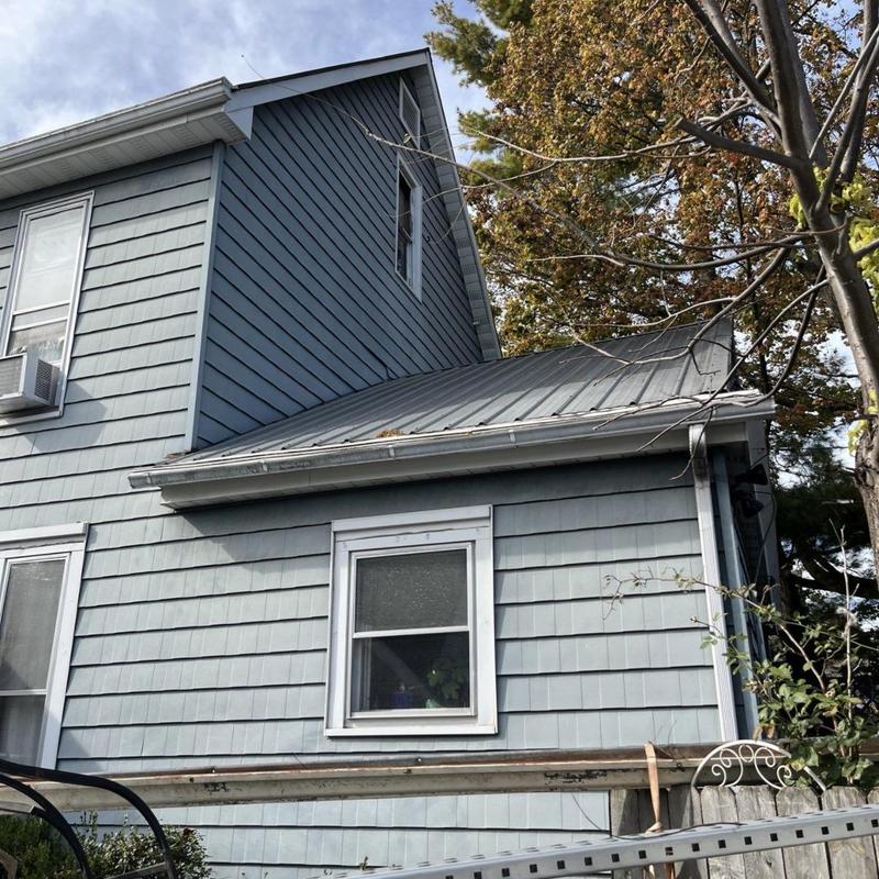Vinyl window installation on blue historic house exterior