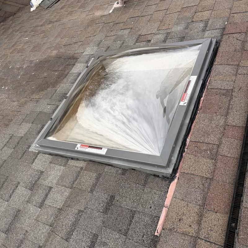 Skylight with new flashing on shingle roof