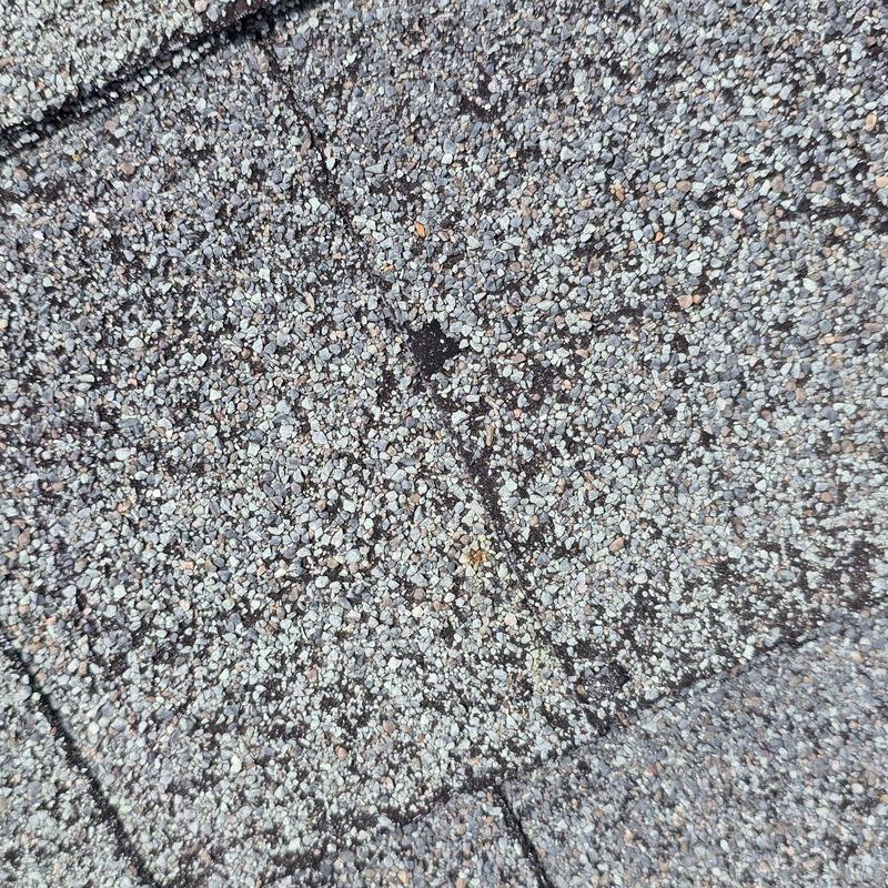 Asphalt shingle roof with hail damage close-up