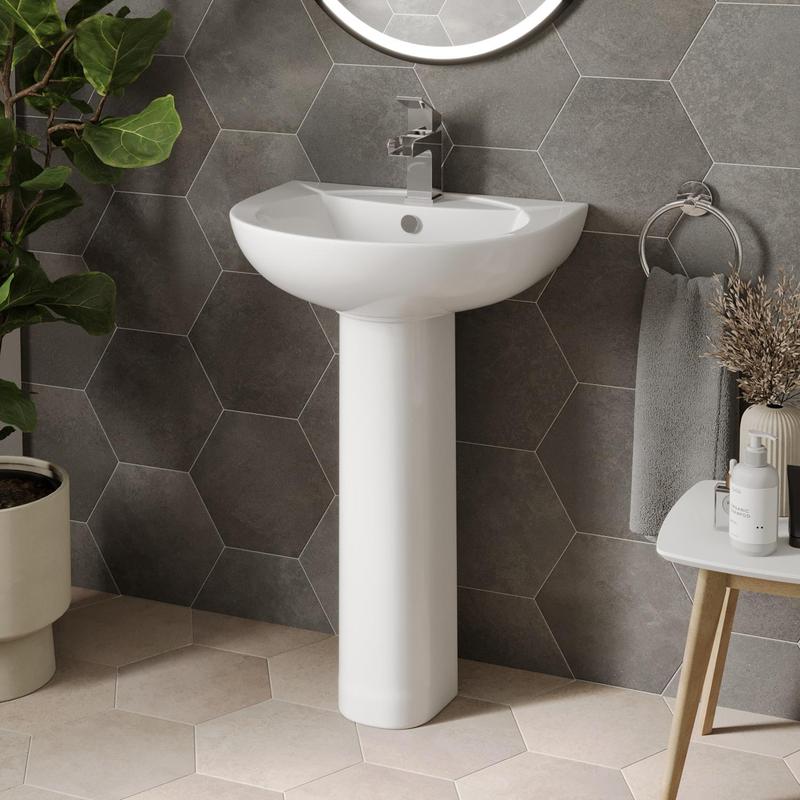 Pedestal sink with modern faucet in bathroom setup