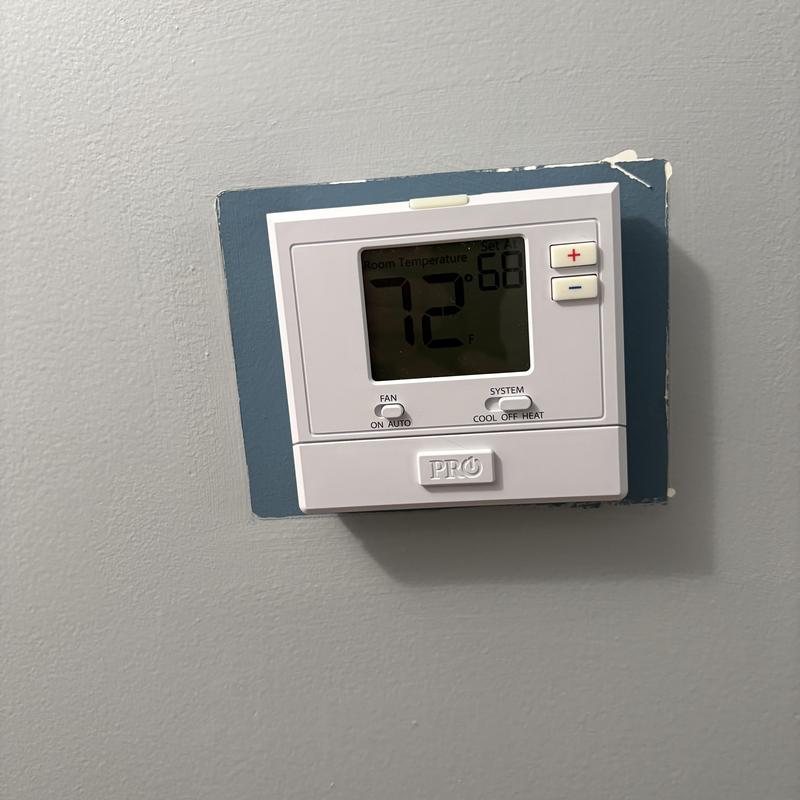 Pro non-programmable heat and AC thermostat on wall