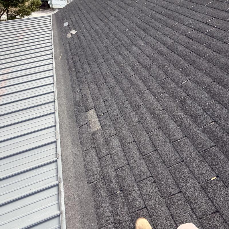 Asphalt shingles with missing pieces on roof section