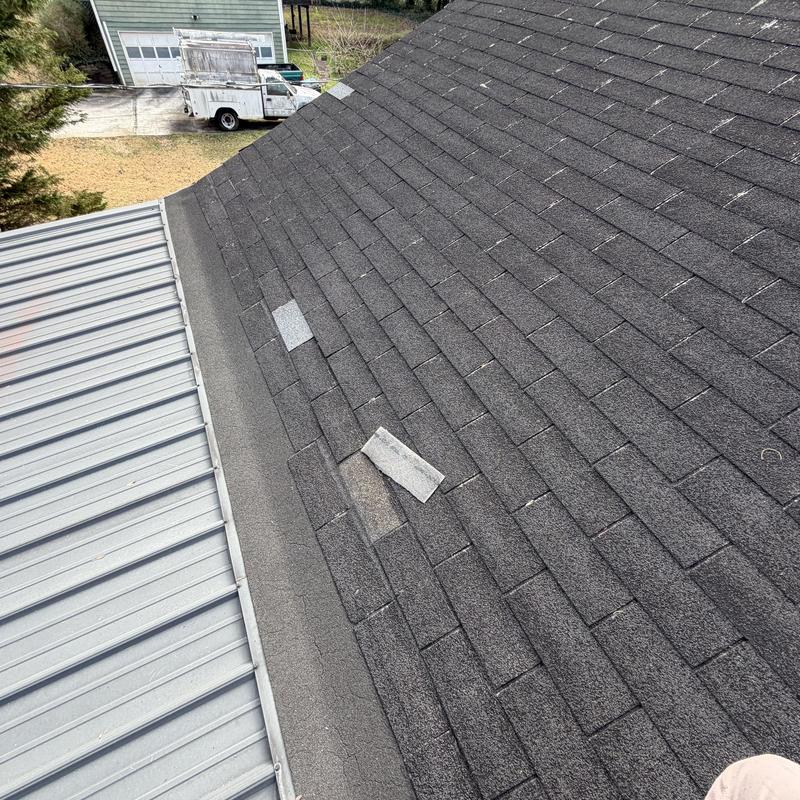 Asphalt shingles with four missing pieces on roof