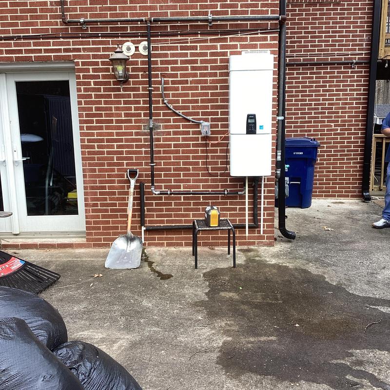 Tankless water heater with plumbing lines outdoors