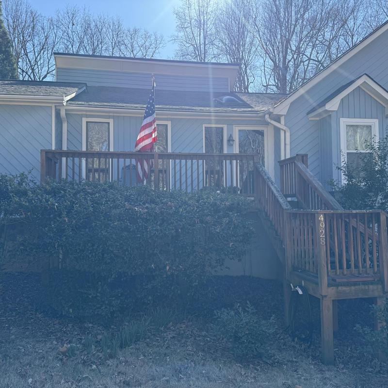 Wooden deck and stairs with American flag in front yard