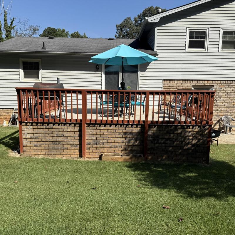 Deck railing and brick foundation with patio umbrella