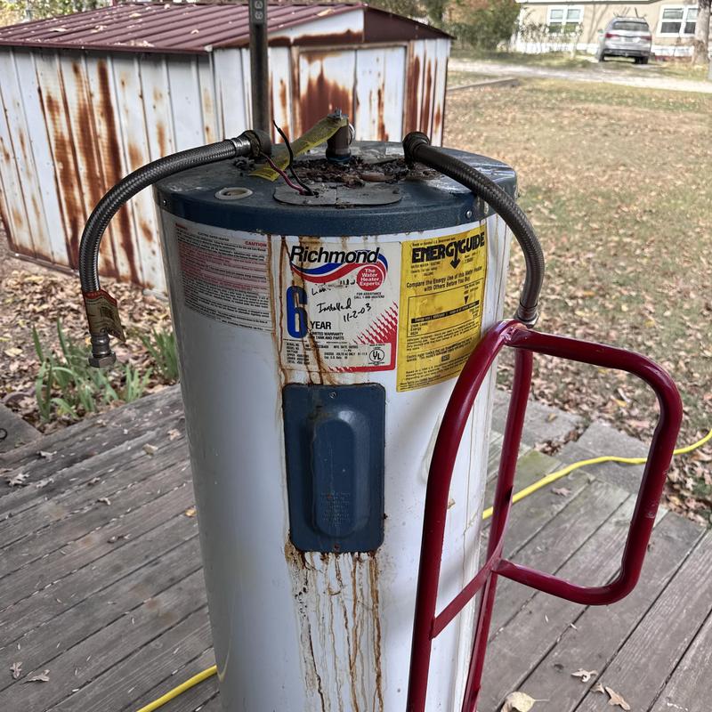 Water heater with leaking and rust stains outdoors
