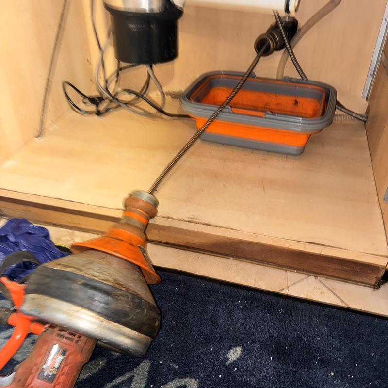 Kitchen sink drain cleaning with plumbing auger tool