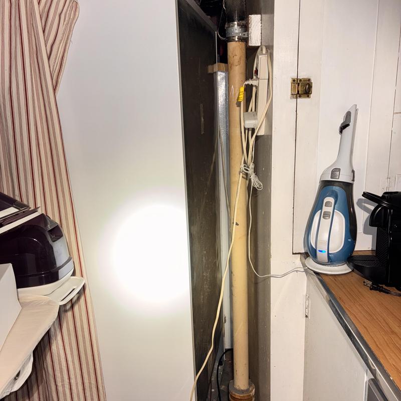 Kitchen sink drain pipe with electrical cords nearby
