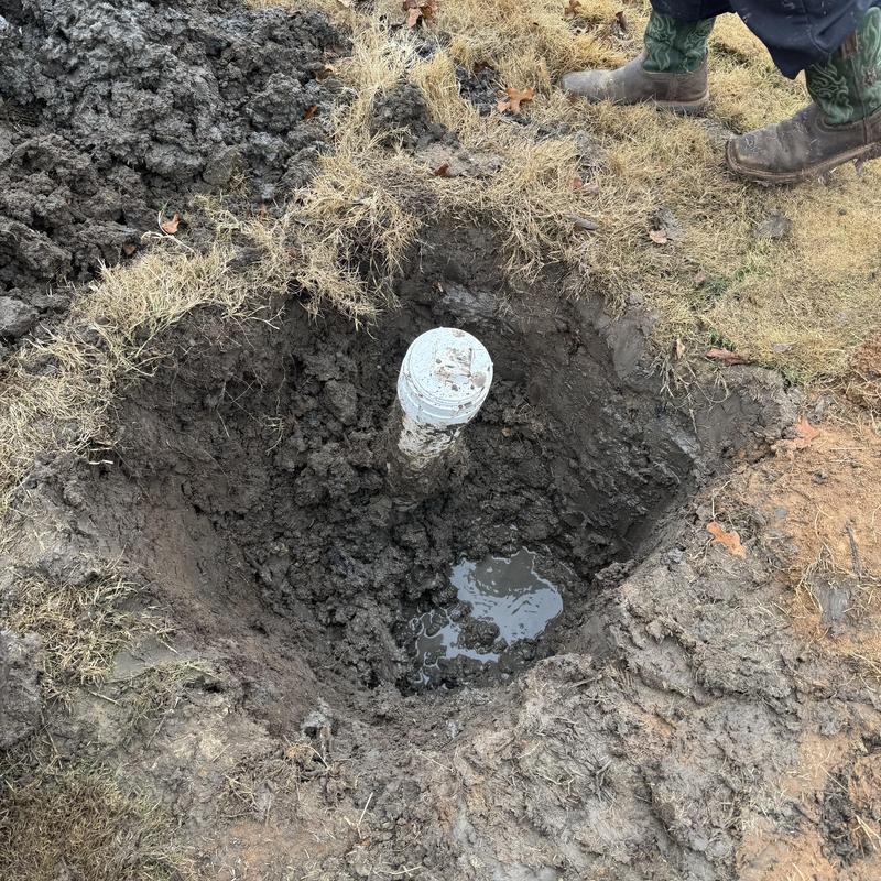 Yard cleanout pipe excavation with muddy soil