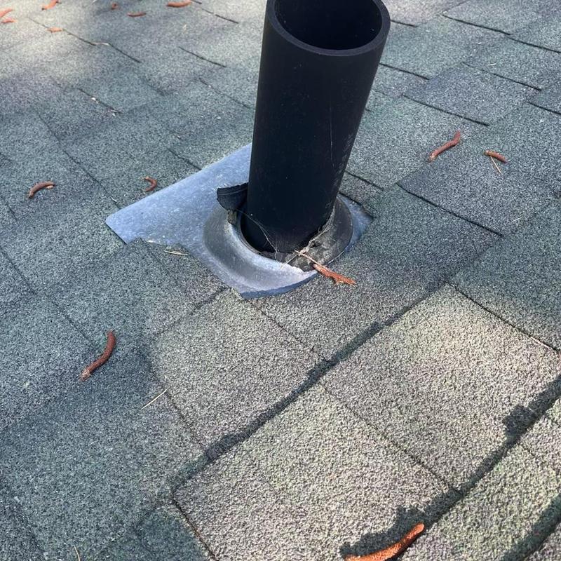Pipe flashing with cracked rubber boot on shingle roof