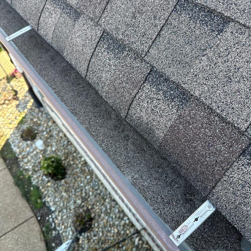 Asphalt shingles roof showing hail damage and gutter edge