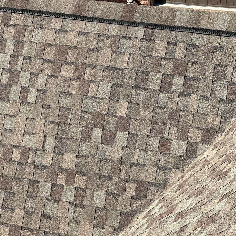 Asphalt shingle roof with ridge cap and hail damage