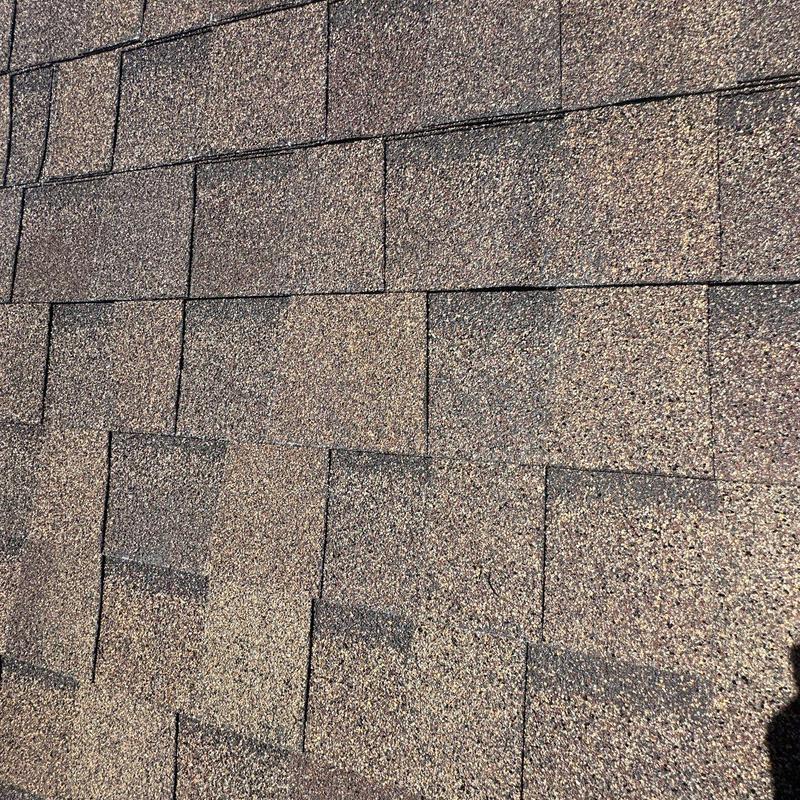 Asphalt shingles with hail damage on roof surface