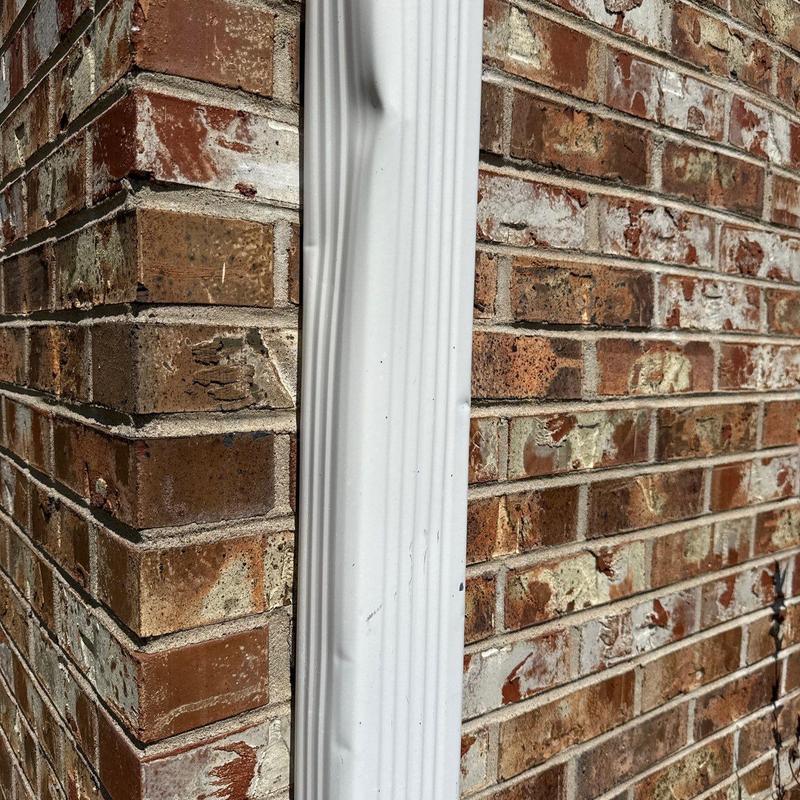 Brick wall corner with metal flashing dents