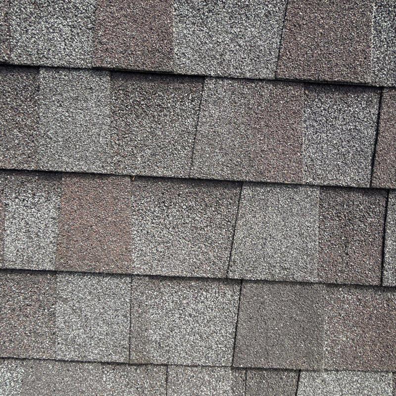 Asphalt shingles with hail damage on roof surface