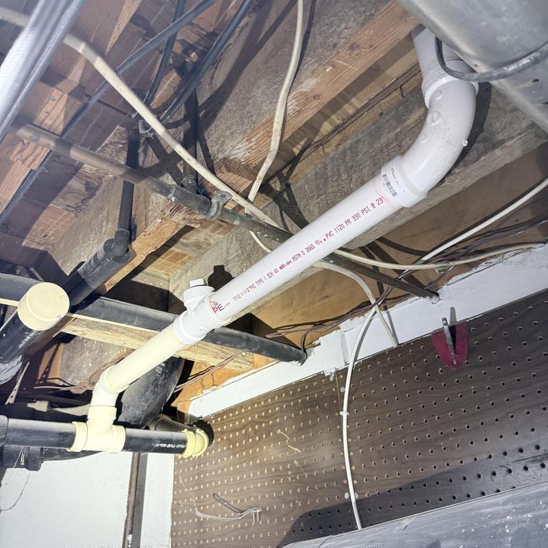 PVC bathroom sink drain repiping under floor joists