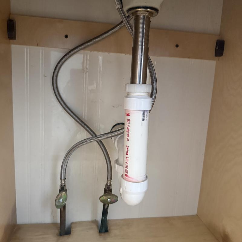 Sink faucet water supply lines and PVC drain pipe under cabinet Sink faucet water supply lines and PVC drain pipe under cabinet