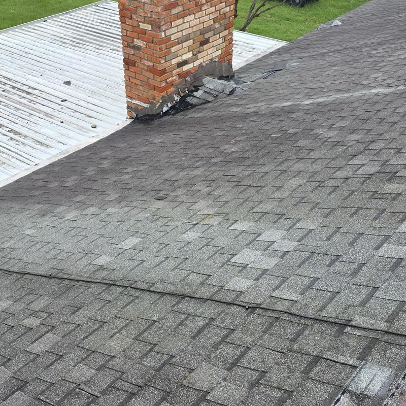 Asphalt shingle roof with chimney flashing replacement