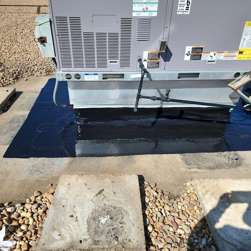 HVAC unit base sealed with black silicone coating HVAC unit base sealed with black silicone coating