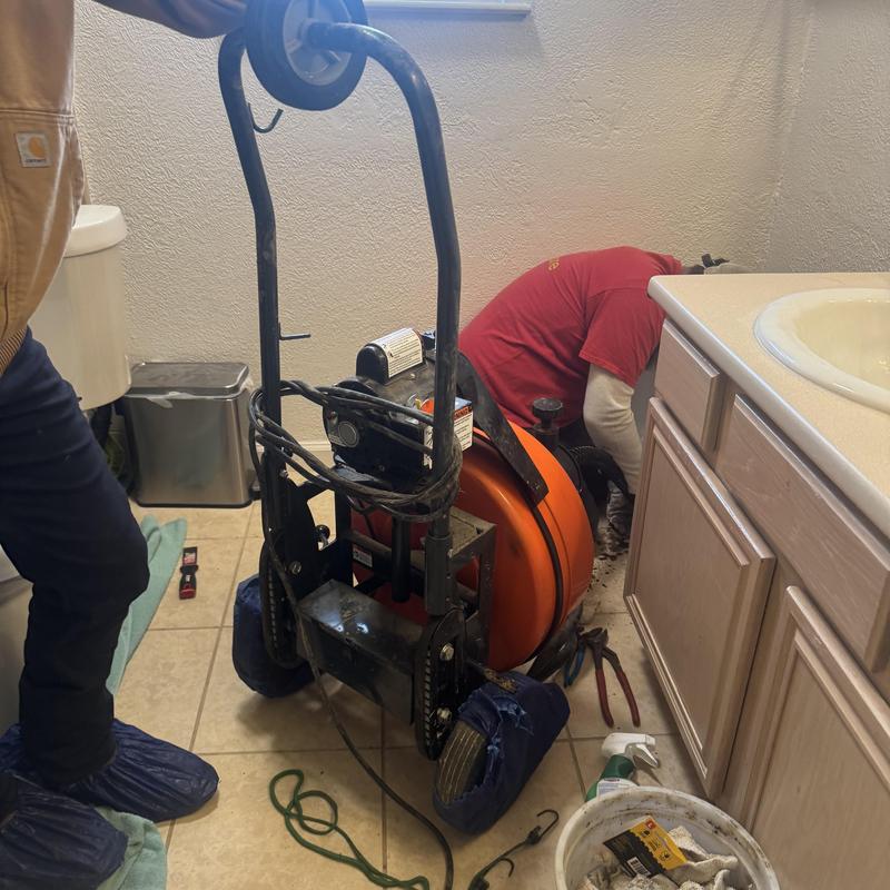 Toilet drain snake machine clearing bathroom sewer blockage