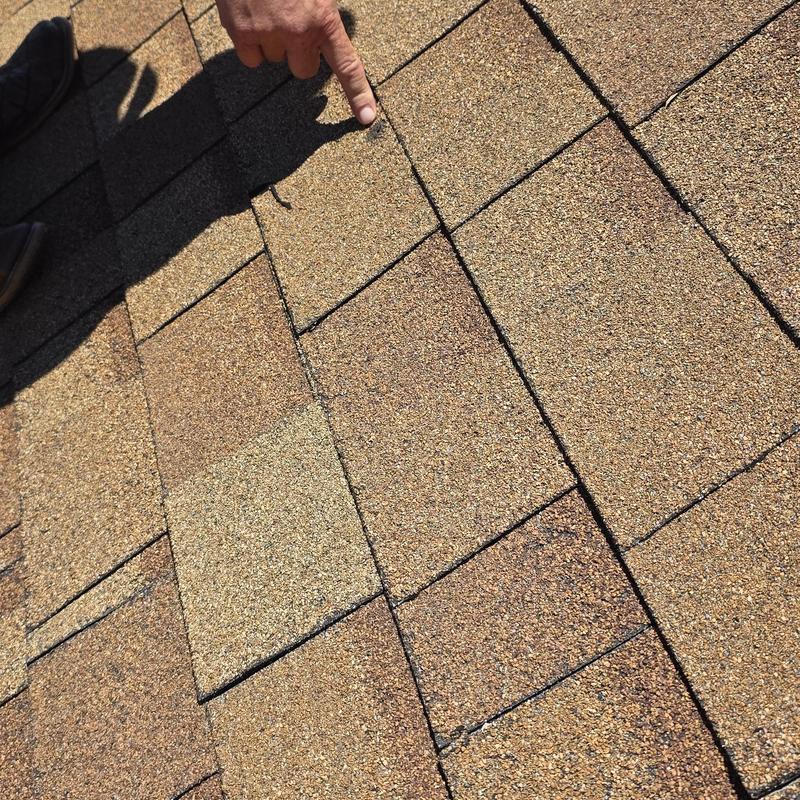 Asphalt shingles with hail damage inspection on roof
