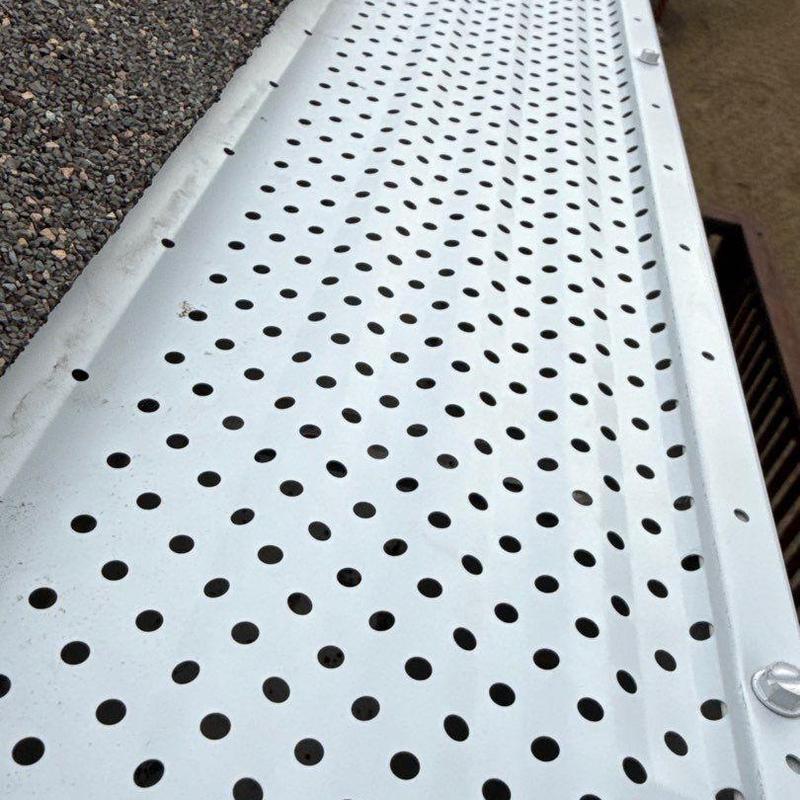 Perforated white aluminum gutter guard system installed