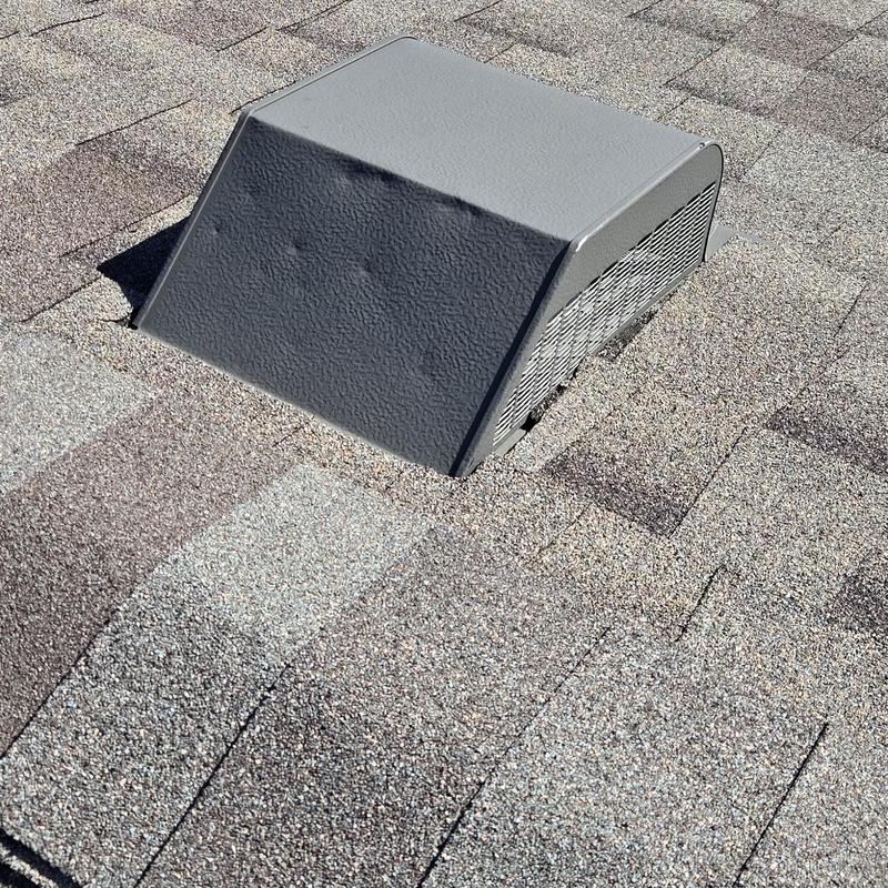 Roof vent with hail impact dents on shingles