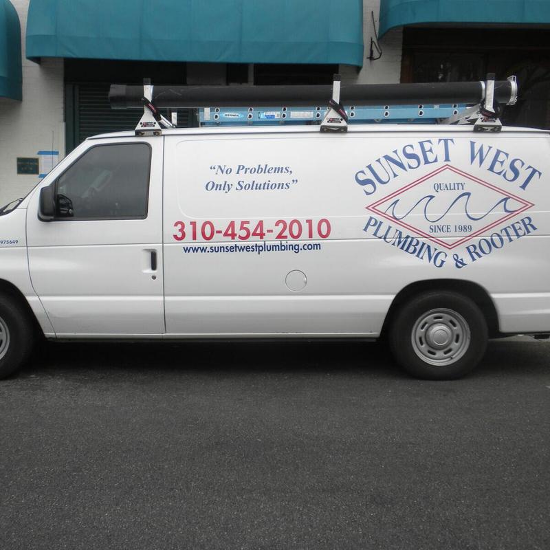 Plumbing service van with ladder on roof rack