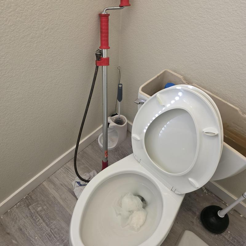 Toilet bowl with snake tool and plumbing supplies
