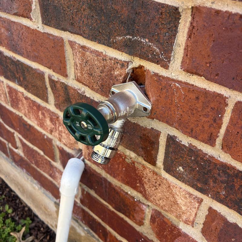 Frost proof hose bib valve on brick wall