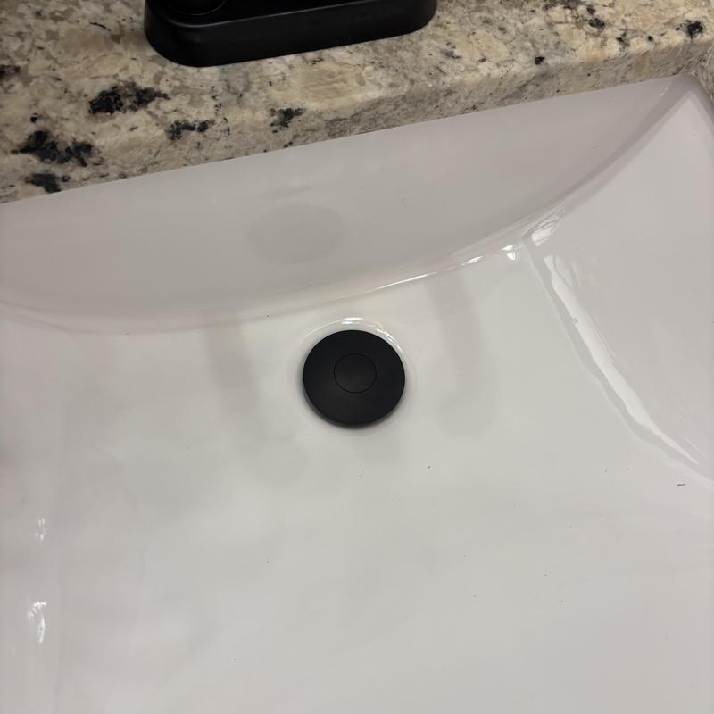 Sink stopper installed in white countertop basin