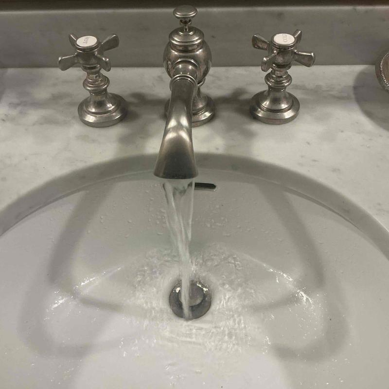 Wide spread bathroom faucet with flowing water