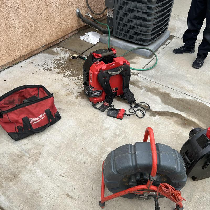 Sewer drain cleaning tools and equipment setup on pavement