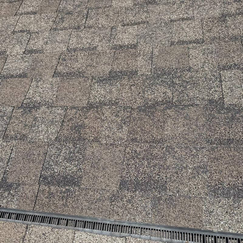 Asphalt shingle roof with hail damage and drainage grill
