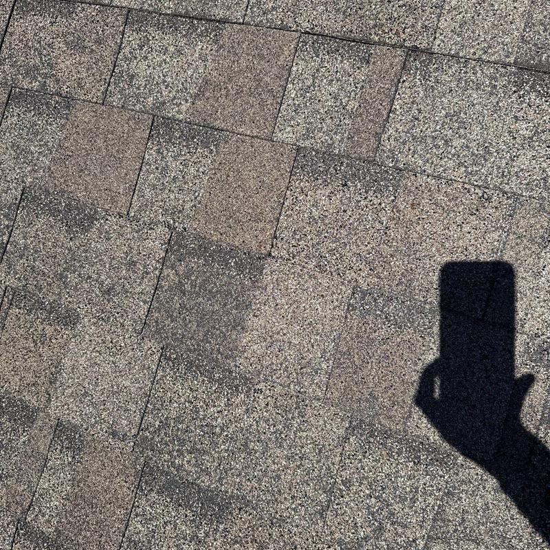 Asphalt shingles with hail damage on roof surface