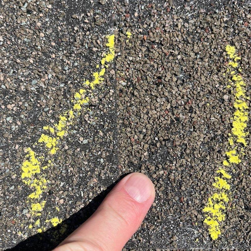 Asphalt shingle roof with marked hail damage close-up