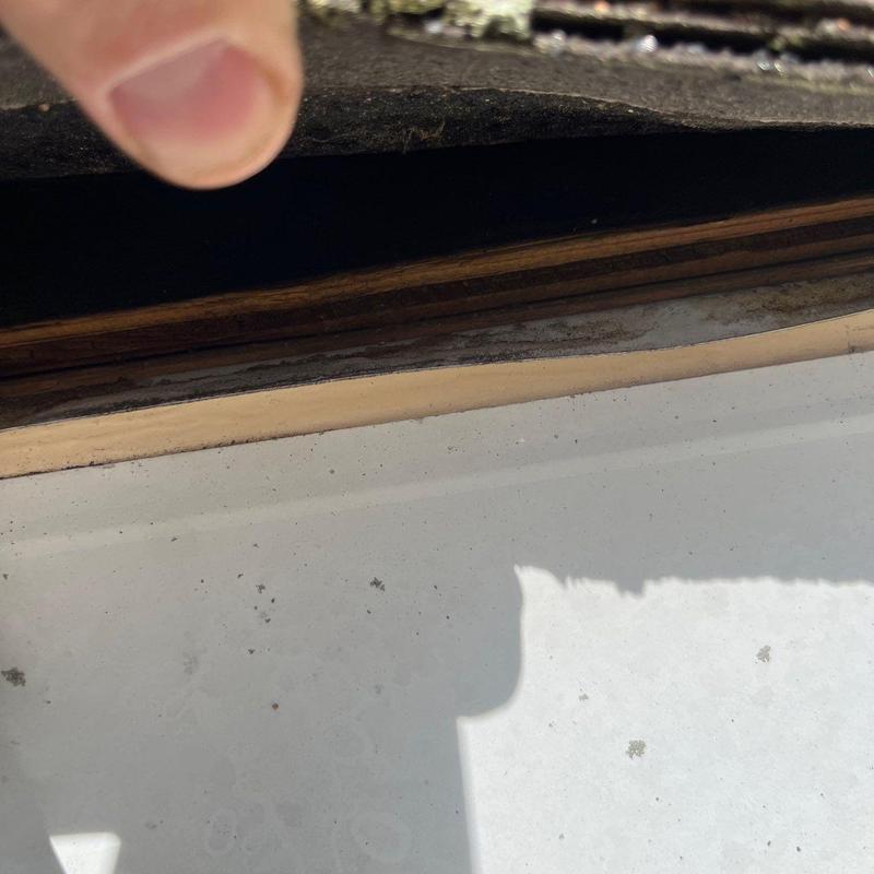 Roof flashing lifted revealing underlying wood decay