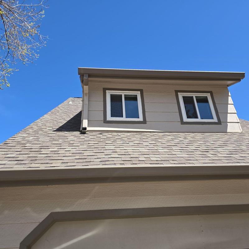 Asphalt shingle roof with window dormer and clear sky Asphalt shingle roof with window dormer and clear sky