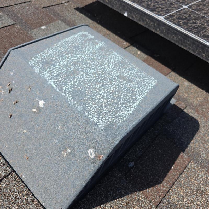 Roof vent with hail damage and debris buildup