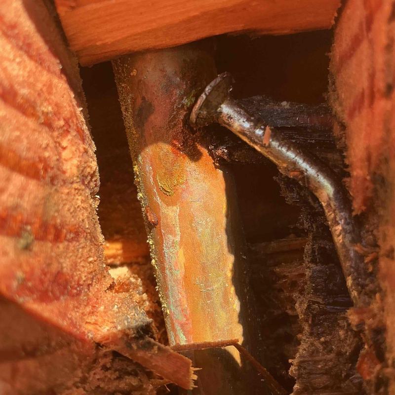 Half-inch copper pipe with framer nail damage inside wall cavity