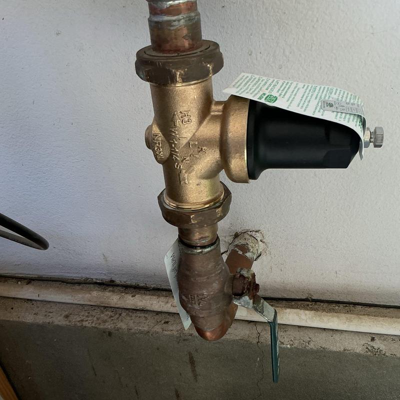 1 1/4 inch Pressure regulator valve with tags near wall