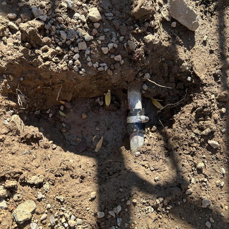 1 inch copper water main with clamp in dirt trench