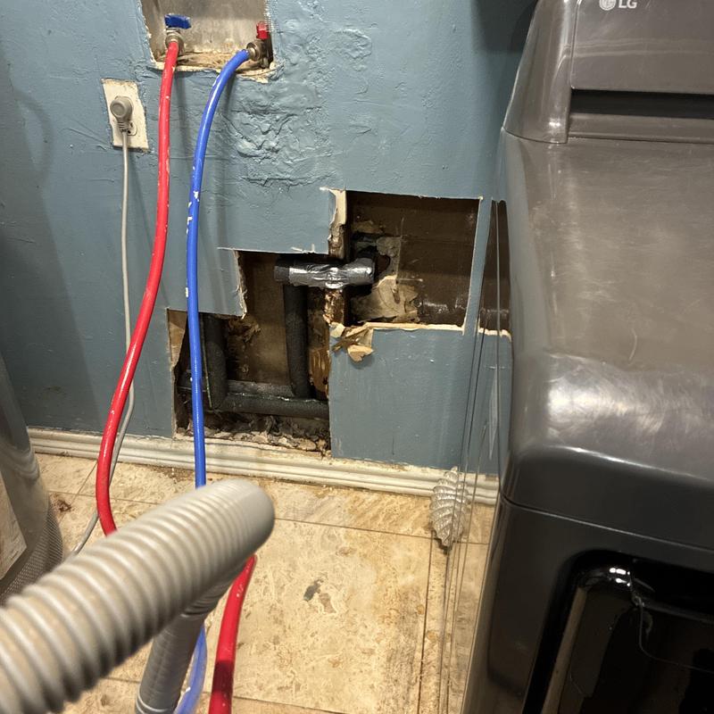 Washing machine water pipes exposed in wall cavity