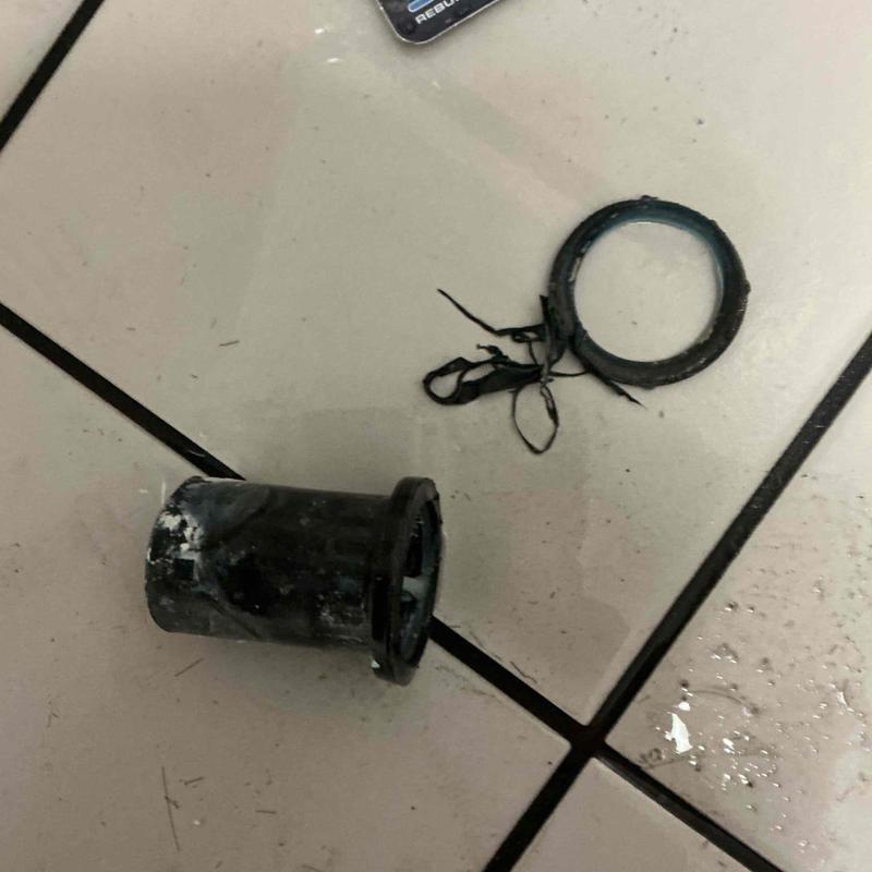 Vacuum breaker and flush valve parts on tile floor