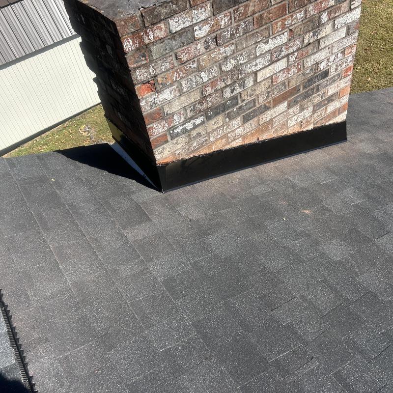 Black shadow shingle roof with brick chimney flashing
