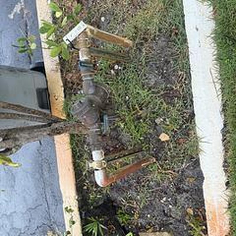 Backflow prevention device with piping in grass area