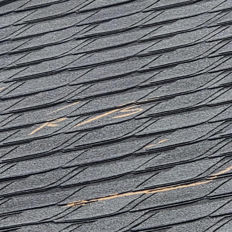 Roof shingles with hail damage marks on asphalt shingles