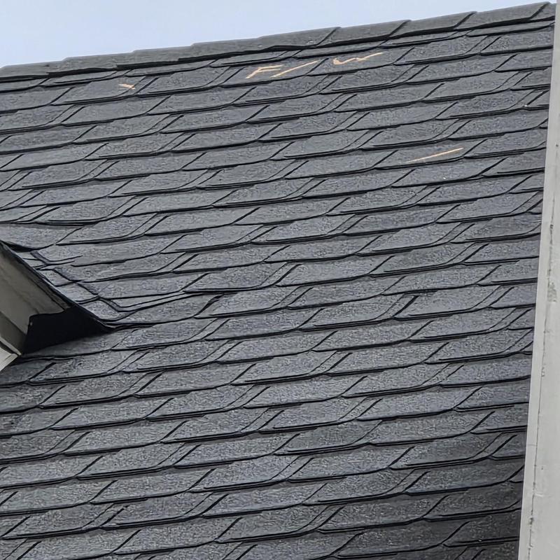 Asphalt shingle roof with marked storm damage areas